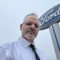 Newport Ford - Shawn Helmick with ford sign in back