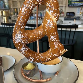 Prost Beer Hall - Huge pretzel with generous cheese sauce. Yes, someone already took a bite! - Cocktail Bars Near Me - Elk Grove, California Prost Beer Hall - Huge pretzel with generous cheese sauce. Yes, someone already took a bite! - Cocktail Bars Near Me - Elk Grove, California