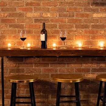 Cellar44 - a brick wall with candles and wine glasses - Wine Bars Near Me - Omaha, Nebraska