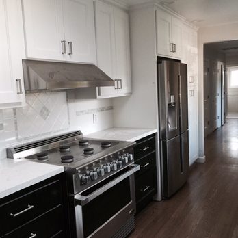 Renovated Square - a kitchen with white cabinets and black appliances - General Contractors Near Me Renovated Square - a kitchen with white cabinets and black appliances - General Contractors Near Me