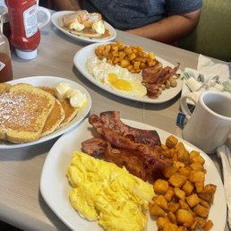 a man sitting at a table with breakfast foods a man sitting at a table with breakfast foods