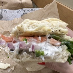 a person holding a sandwich in their hand