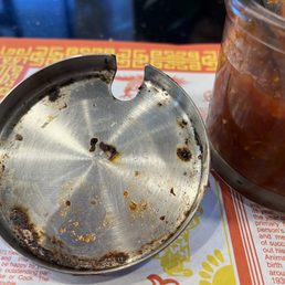 Lid on top of paste with water in it, stored in the non-refrigerated condiments on the table.