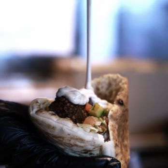 Holy Grill - a hand holding a pita sandwich - Kosher Near Me - Los Angeles, California Holy Grill - a hand holding a pita sandwich - Kosher Near Me - Los Angeles, California
