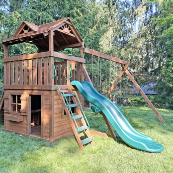 Creative Playthings - A wooden residential swing set with a bottom level clubhouse from Creative Playthings. Shown in a backyard on grass. - Playsets Near Me - Holliston, Massachusetts Creative Playthings - A wooden residential swing set with a bottom level clubhouse from Creative Playthings. Shown in a backyard on grass. - Playsets Near Me - Holliston, Massachusetts