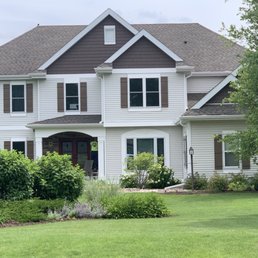Shakers added to roofline, stone entry added with new doors, windows, shutters, and eaves troughs around the house.