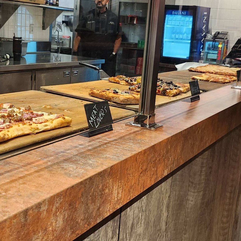 Hidden Pizza - a variety of pizzas on a counter - Pizza Near Me - Reno, Nevada Hidden Pizza - a variety of pizzas on a counter - Pizza Near Me - Reno, Nevada