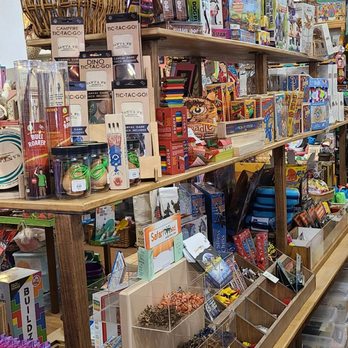 Doodlet's - Toys toys TOYS! - A toy and gift shop displays shelves stocked with board games, craft supplies, and small toys, with organized containers and a wicker basket on top. - Toy Stores Near Me - Santa Fe, New Mexico
