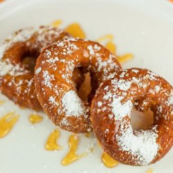 Santorini's - Loukoumades at Santorini's Farmington: Golden fried Greek donuts with powdered sugar and honey. The perfect treat at Farmington Station!