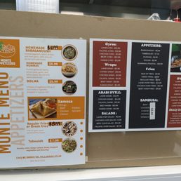 Sign to the left of the cash register. According to the sign on the right, bottom left, "LAMB OVER SALAD - $12.99" Sign to the left of the cash register. According to the sign on the right, bottom left, "LAMB OVER SALAD - $12.99"