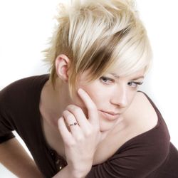Salon Bravissimo - Edgy blonde pixie haircut with textured layers, dramatic volume, and a bold modern finish.