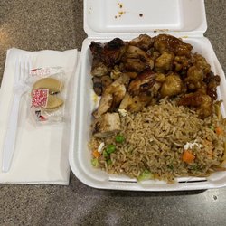 Happy Dragon - To-go order of BBQ chicken, orange chicken, and rice/noodle mix.
