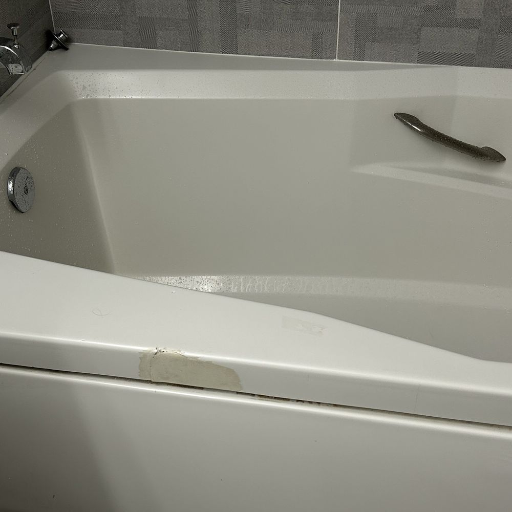 Damaged bathtub poorly repaired.