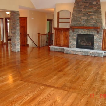 Hardwood Connection - a living room with wood floors and a stone fireplace - Flooring Near Me - Deer Park, Washington