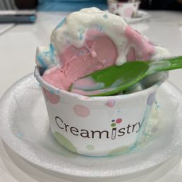 Unicorn ice cream with whipped cream , unicorn dust, and marshmallows
