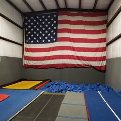 Missy's Gymnastics - Our huge flag overlooks the trampolines and the foam pit in our gym area.