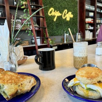 Origin Coffee - 2 vegan sandwiches and a cold brew with salted caramel and some type of fun creamy foam. - Coffee & Tea Near Me - Lake Placid, New York Origin Coffee - 2 vegan sandwiches and a cold brew with salted caramel and some type of fun creamy foam. - Coffee & Tea Near Me - Lake Placid, New York