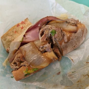 Paseo - Paseo Press (Roasted pork shoulder, smoked ham, banana peppers, fresh cilantro, caramelized onions, and melted Swiss cheese) - Caribbean Near Me - Issaquah, Washington