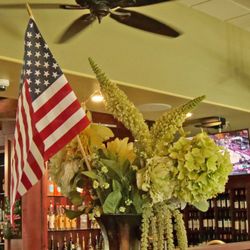 Cast Iron Grill and Bar - Flowers and a flag, part of the pleasant decor in the restaurant.