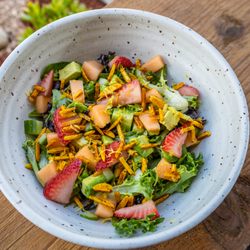 Miso Garden Salad: spring mix, miso ginger vinaigrette, avocado, cucumber, cantaloupe, pickled strawberry & spiced curry almonds