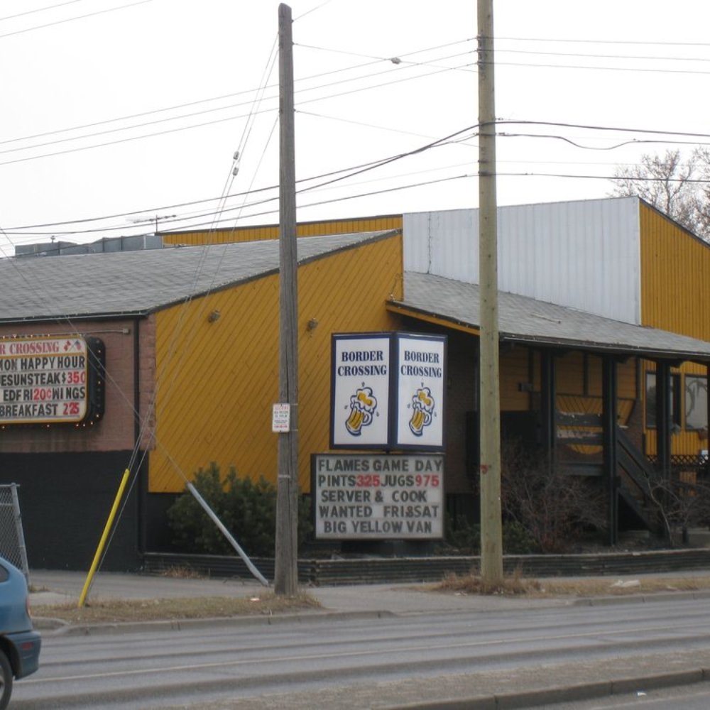Border Crossing - a yellow building and a blue car - Steakhouses Near Me - Calgary, Alberta Border Crossing - a yellow building and a blue car - Steakhouses Near Me - Calgary, Alberta