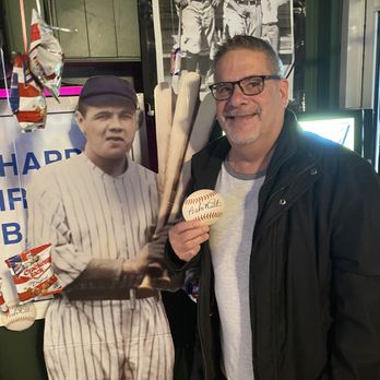 Duffy's Den - a man holding a baseball and a baseball bat - Sports Bars Near Me - Detroit, Michigan