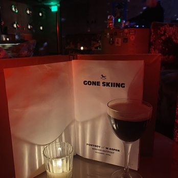 Ponyboy Aspen - a glass of wine next to a menu - Cocktail Bars Near Me - Aspen, Colorado Ponyboy Aspen - a glass of wine next to a menu - Cocktail Bars Near Me - Aspen, Colorado
