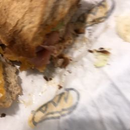 a half eaten sandwich on a piece of paper