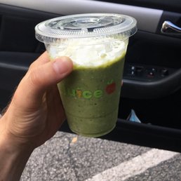 a hand holding a green smoothie a hand holding a green smoothie