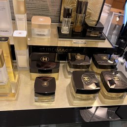 Chanel - Chanel skincare and fragrance products are arranged on a display shelf, including Sublimage creams and Chanel No. 5 perfume bottles.