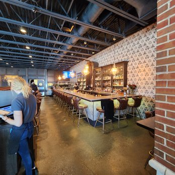 Bourbons - a woman sitting at a bar - Southern Near Me - Brighton, Michigan