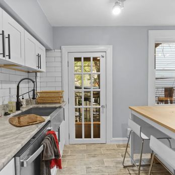 Muirhead Home Restorations - a kitchen with white cabinets and wood countertops - General Contractors Near Me Muirhead Home Restorations - a kitchen with white cabinets and wood countertops - General Contractors Near Me