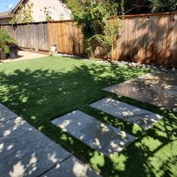 Artificial turf with stepping stone and concrete pad Artificial turf with stepping stone and concrete pad