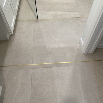 Emser Tile - Clever use of Schluter polish brass details with Polished and Matte Oversized tile - Building Supplies Near Me - Houston, Texas