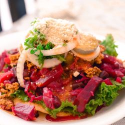 Guatemalan Enchiladas are different from Mexican Enchiladas. Made with meat and Beets as the base topped with onions cheese and an egg