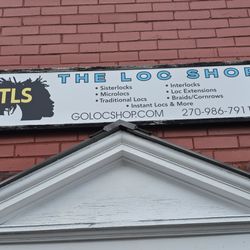 The Loc Shop - Outdoor sign showing services offered, website, and contact number.