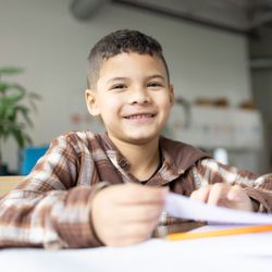 Fraser Woods Montessori School - Student smiles while working at Fraser Woods Montessori School in Newtown, CT.