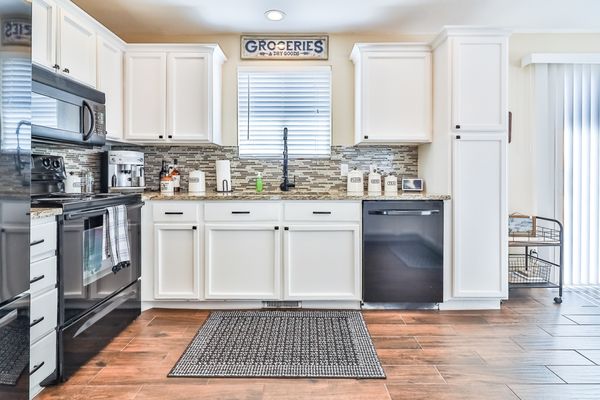 Kitchen remodel 202 - This remodel was finished in 2023, complete with all new kitchen cabinets, quartz countertops, new appliances, beautiful wood grain floor tile, and even a beautiful full length stained wood accent wall.