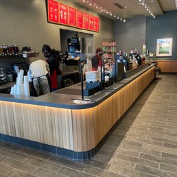 a coffee shop counter with people working a coffee shop counter with people working