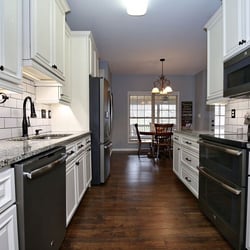 White cabinets, granite countertops, custom lighting and flooring ... another beautiful kitchen remodel by Savvy Home Supply.