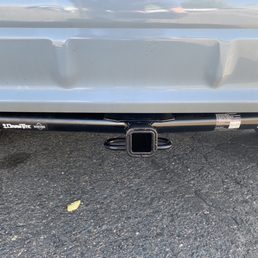 1 1/4" hitch receiver installed by Lampert Hitch in Arvada - The image shows the rear of a vehicle with a square trailer hitch receiver mounted underneath, on a paved surface.