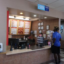 a woman standing at the counter of a fast food restaurant