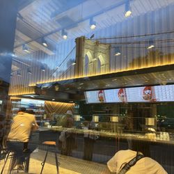 Inside. View of Brooklyn bridge while eating with inside in reflection.