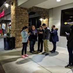 Zombie Scavengers - Sandy Springs - This is what a group of Zombie Scavengers looks like in Sandy Springs. A group of people standing on the sidewalk on their phones.