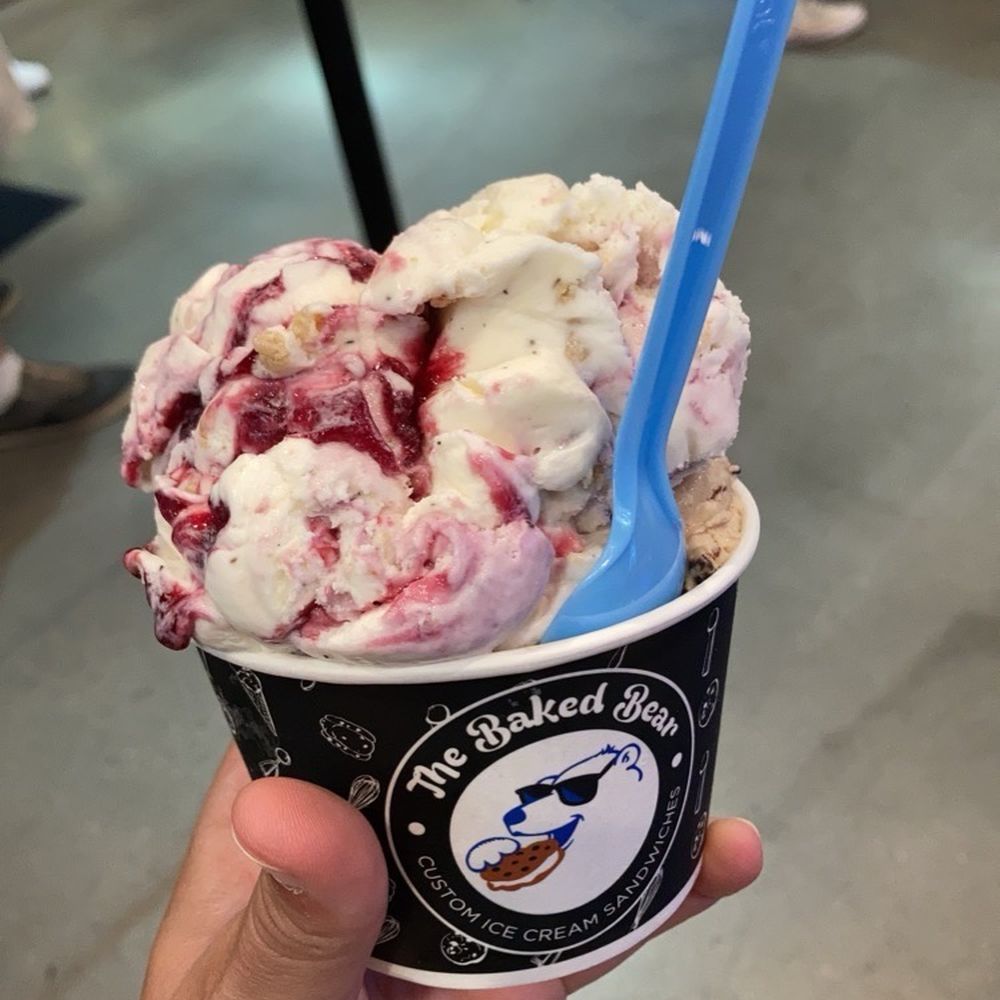 a hand holding a cup of ice cream