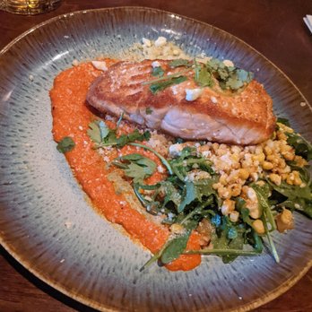Tombo Grille - Salmon with cous cous, arugula corn salad red pepper smear of sauce. Yummy! - New American Near Me - Columbia, South Carolina