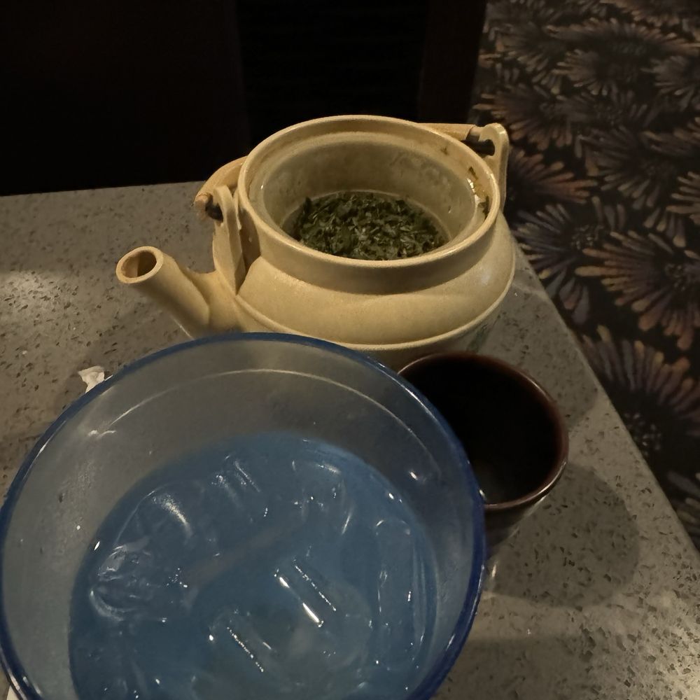 Water and green hot tea served without a lid. Water and green hot tea served without a lid.