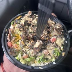 Jerk chicken bowl with rice, black beans, cheese, lettuce, and tomatoes