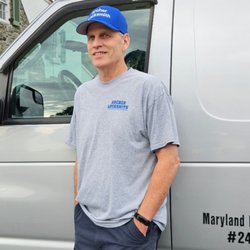 Archer Locksmith - Raymond standing next to work van in blue hat.