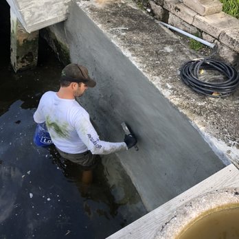 Hydros Marine Construction - Applying a broom finish to a Coral Rock Seawall refacing. - General Contractors Near Me Hydros Marine Construction - Applying a broom finish to a Coral Rock Seawall refacing. - General Contractors Near Me